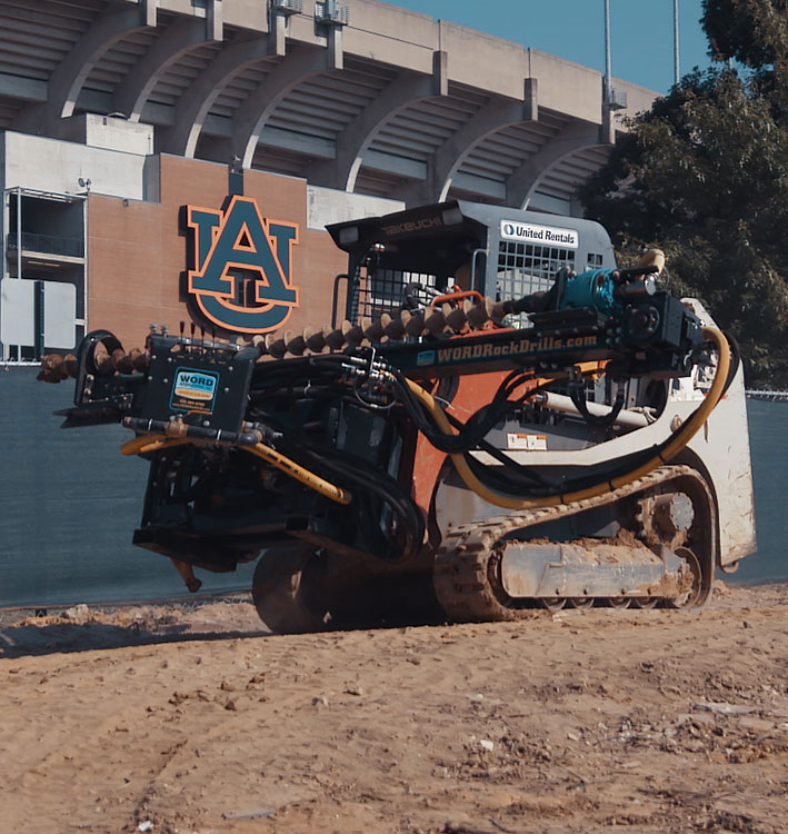 WORD Skid Steer Attachment soil nailing at Auburn University football stadium. 